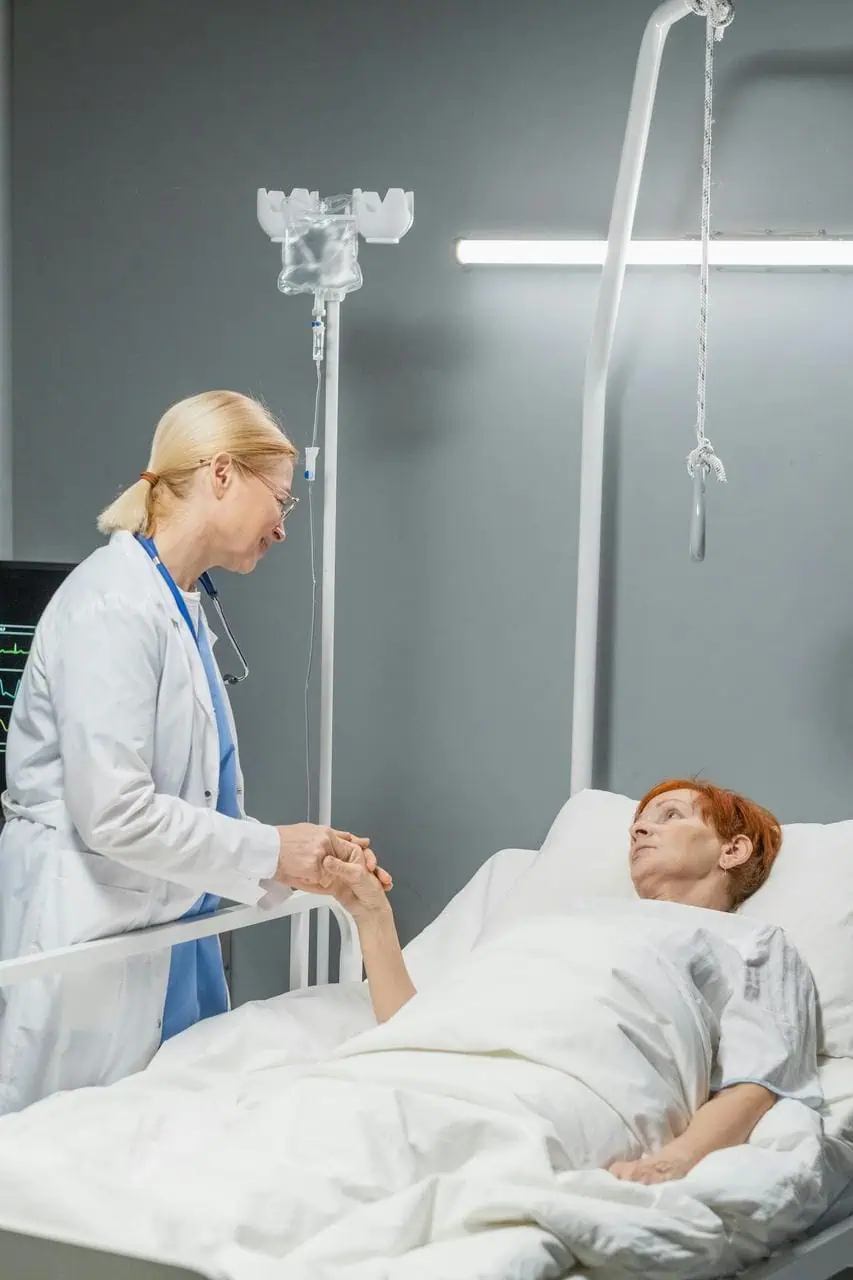 Palliative care nurse providing comfort support to patient in hospital bed