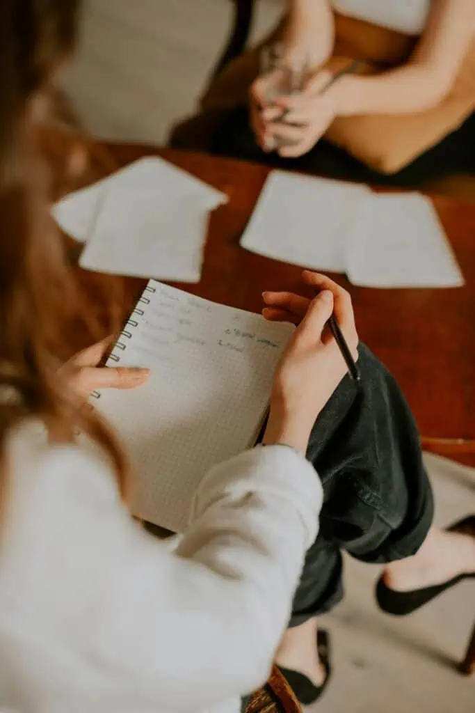Patient advocacy consultant taking detailed notes during client rights consultation meeting