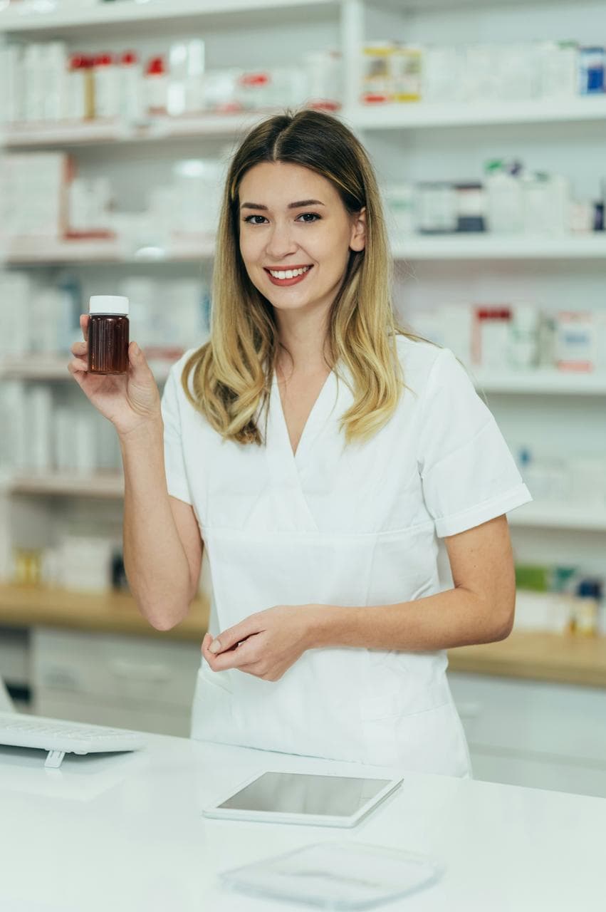 Pharmaceutical sales representative holding medication bottle in pharmacy dispensing area