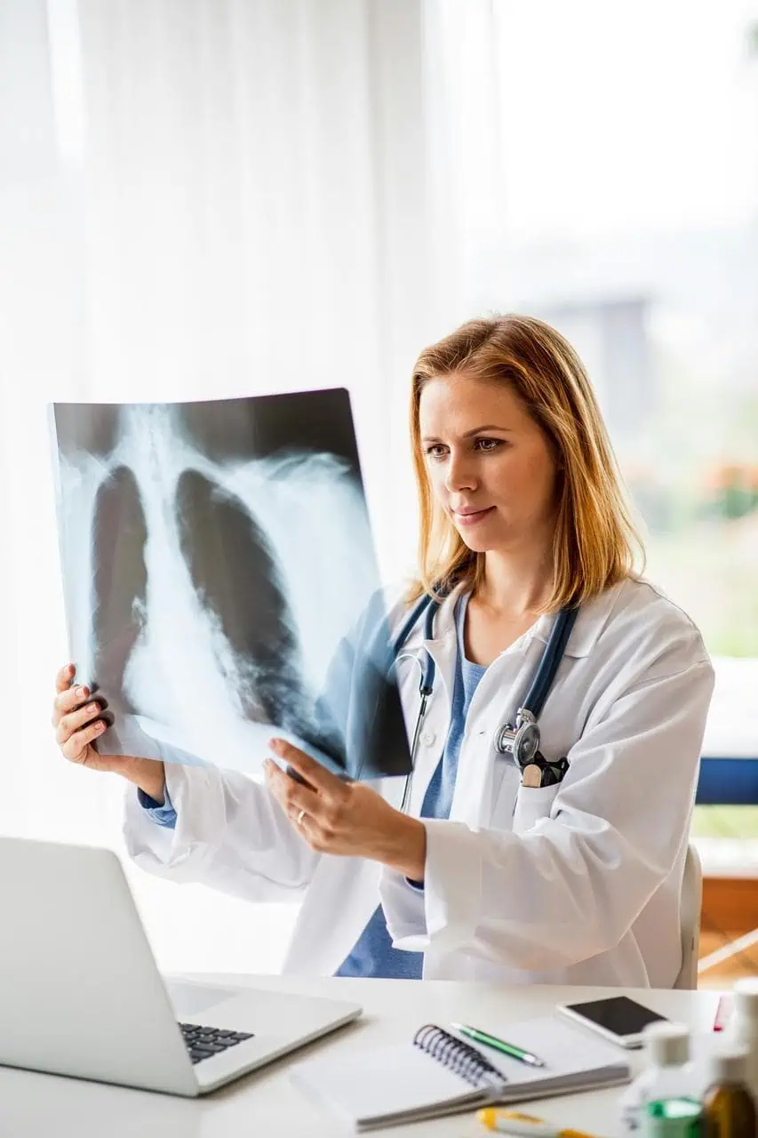 Female radiologist examining chest X-ray with stethoscope in medical office