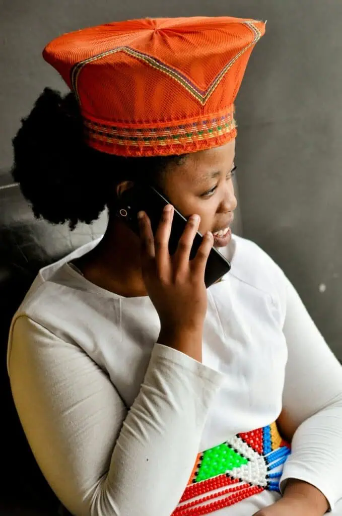 Social worker wearing traditional cultural headwrap conducting phone consultation with client
